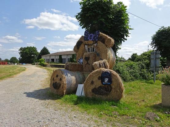 au bord de la route, un nounours en grosses bottes de foin rondes