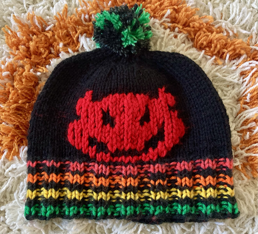 A black and colorful hand-knit beanie with an image of Bowser Koopa