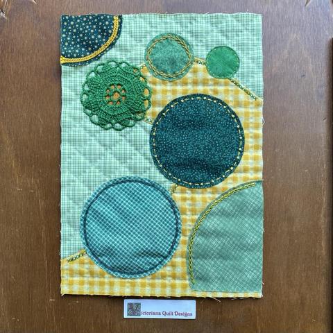 Green and yellow mini quilt, with circles. 