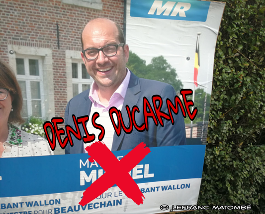 Une affiche électorale montre un homme souriant, Mathieu Michel, avec des lunettes et une chemise bleue. Le logo du parti MR est visible. Un grand « X » rouge est dessiné sur la partie inférieure de l'affiche, cachant le nom de Mathieu Michel et le texte « DENIS DUCARME » est superposé en rouge sur l'image.