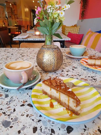 Zwei Teller mit veganem Bastogne Cheesecake und zwei Cappuccino mit Hafermilch bei ETN in Enschede.