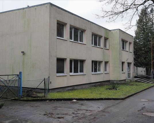 Zweigeschossiges Haus mit Flachdach und frontseitigen Fenstern.