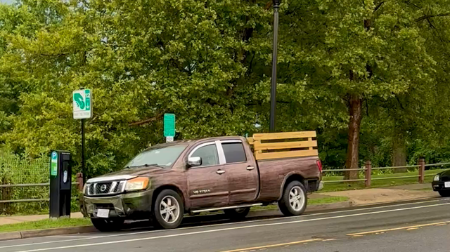 A truck that appears brown at first but as I walk up parallel to it, it turns green and then back to brown. 
