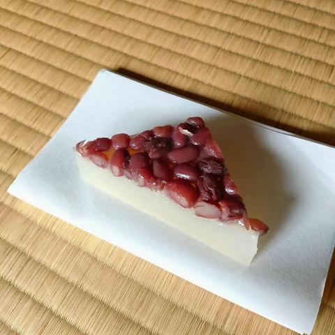 A traditional triangular sweet known as minatsuki or mizazuki. Red beans cover a layer of soft mochi.