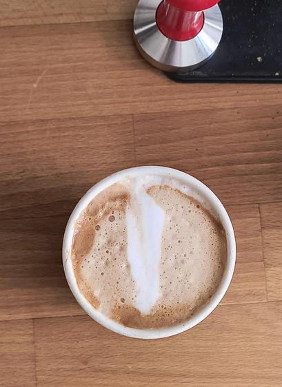 Eine Tasse mit Cappuccino. Das Muster des Milchschaumes ist nicht eindeutig zu identifizieren, es bleibt jedem selbst überlassen, was er/sie darin sieht. 