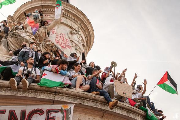 Sur le premier niveau de la statue centrale, des manifestants scandent leur soutien à la Flottille de la liberté. Certains brandissent des drapeaux palestiniens. En arrière-plan, l’inscription « Free Palestine » a été tracée en rouge sur le monument.