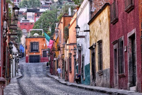 Multi-colored single-story attached homes along a cobblestone street