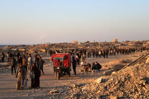 Des Palestiniens marchent à la recherche des camions d’aide des Nations Unies entrant dans le nord de Gaza, à Beit Lahia, dans le nord de la bande de Gaza, le 18 juin 2025. 