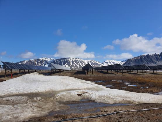 Solcelleanlegg med arktiske fjell i bakgrunnen 