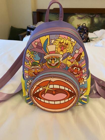 A mini backpack Dr Teeth and the Electric Mayhem with their signature mouth logo forming a round front pocket and two side pockets with fringe hanging off.