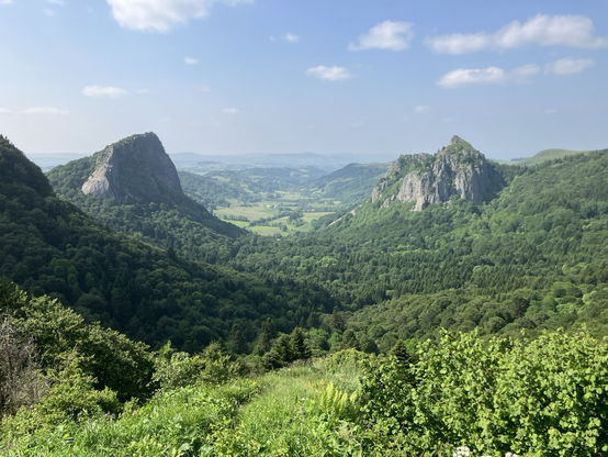 The image displays a scenic view of the Roches Tuilière and Sanadoire in the Puy-de-Dôme department of France