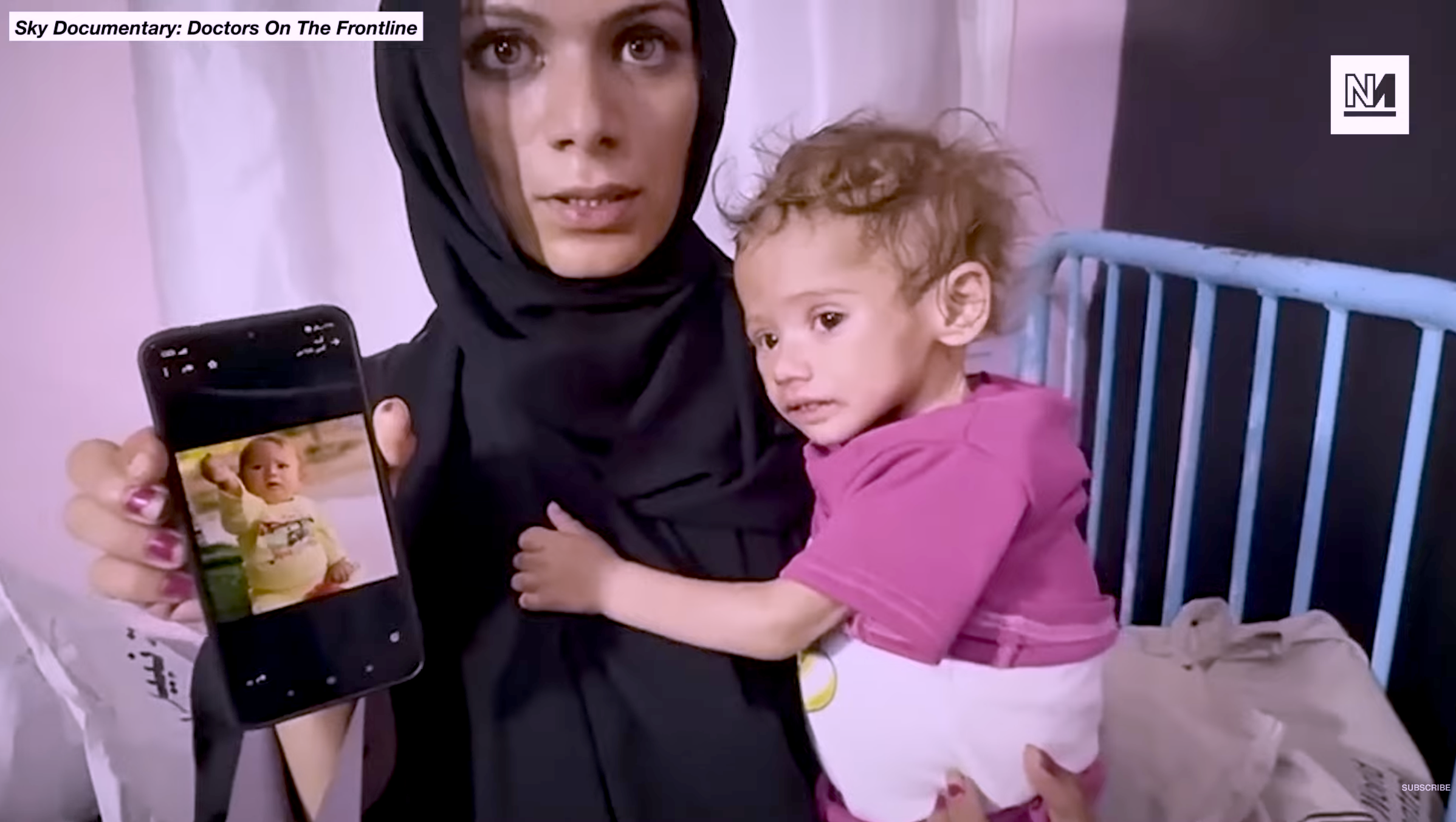 malnutrition mother holding a very malnutrition baby and a mobile phone showing that baby when it wasn't dying of hunger