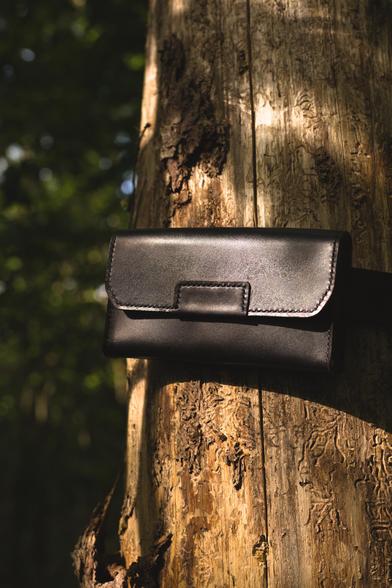 Black small belt bag is attached to the tree.
