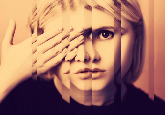 An amber-tinted photo of a woman covering one eye. The appearance of the photo is composed of several split reflections.