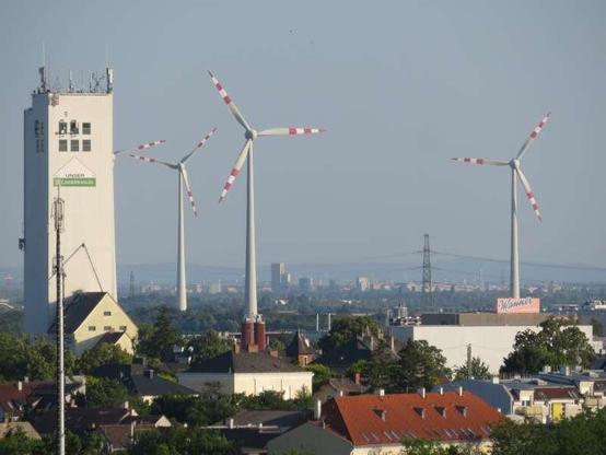 Blick auf Lagerhaus und Manner-Werk in Wolkersdorf, im Hintergrund Windräder und die Silhouette Wiens