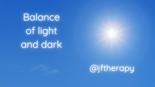 A mostly clear blue sky with a bright sun and some faint clouds and the text says Balance of light and dark and @jftherapy in white glowing text