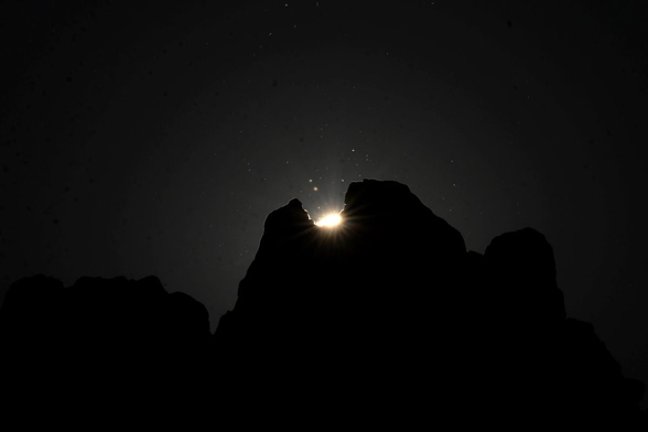 Sliver of sun shining through groove in rock.