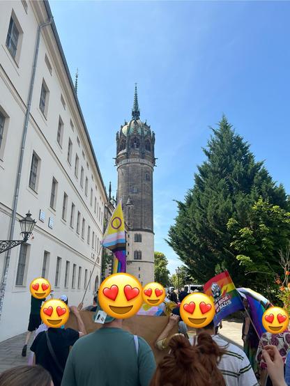Demozug kurz vor der Schlosskirche, auf deren Turm oben die Pride Flag zu erkennen ist.
