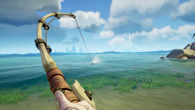 A fishing rod is aimed at the water, with a splash visible where the line meets the surface. The background features a serene ocean, grassy shoreline, and distant islands under a partly cloudy sky.