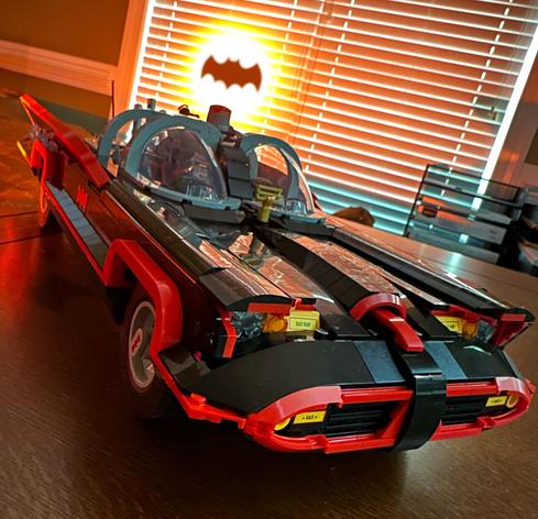 The 1966 Lego Batmobile sitting on my dining room table with a glowing bat symbol in the background