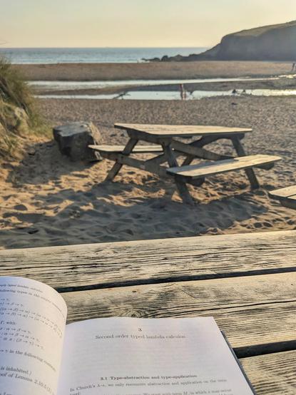 Chapter 3 of book open on a bench on a beach at sundown 