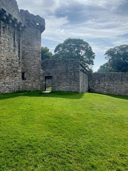 Dramatic castle wall, manicured courtyard grass