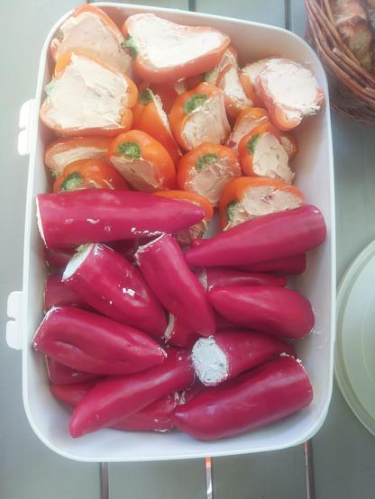 Kleine Paprika in rot und Orange mit Frischkäse gefüllt.