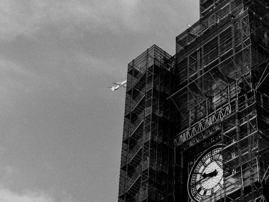 Big Ben unter einem Gerüst mit einem Flugzeug darüber