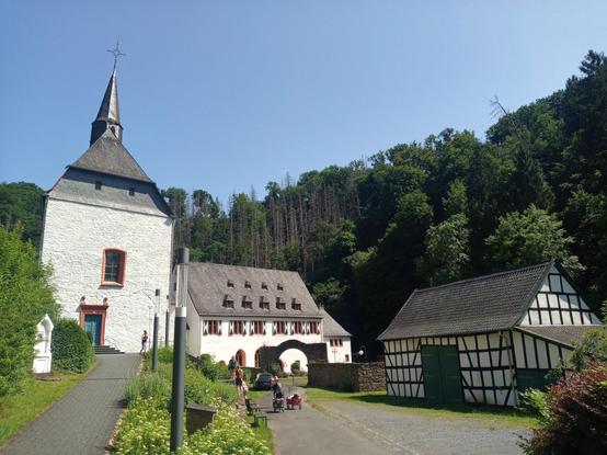 Kloster Ehrenstein monastery. A church-like building to the left, a historic residential home in the back and a half-timered bard to the right.