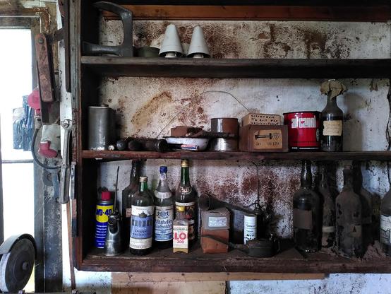 Ein uraltes Regal mit lauter seltsamen Flaschen und Utensilien.