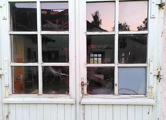 Ein abblätterndes Tor mit Sprossenfenstern.