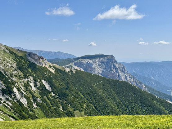 View from a mountain plateau to a steep ridge, another plateau with 400 meter high rock faces, and in the background the silhouette of the Schneeberg (2,076 m).