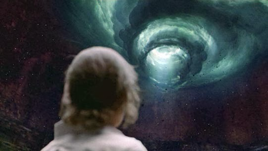 Detective Rust Cohle from the HBO series True Detective stands with his back to the viewer, looking up at a massive spiral vortex of green and white light swirling surreally in a cave. Cohle, identifiable by his short blonde hair, gazes at the otherworldly phenomenon in this surreal scene from the Season 1 finale. The spiral dominates the cave, creating a mystical and haunting image that reflects the show’s themes of cosmic horror and philosophical mystery.