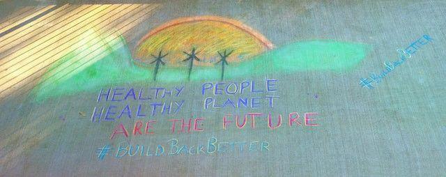 An image drawn in chalk of healthy people, healthy planet.