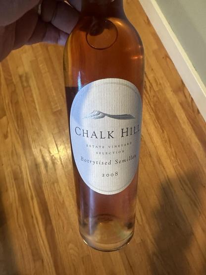 Front of a sweet botryized Semillon from Australia.  A 2008 Chalk Hill Estate Vineyard Selection Botryized Semillon to go with our dessert.  The image is a black and white drawing of a short hill with the peak off center on the left.

Scanned from bottle:

“CHALK HIL
ESTATE VINEYARD
SELECTION
Botrytised Semillon
2008”
