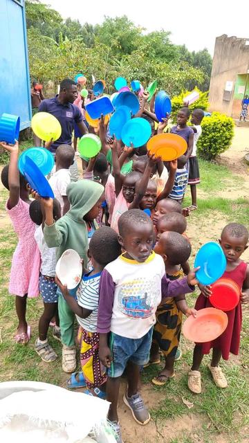 Young children lining up for food. 