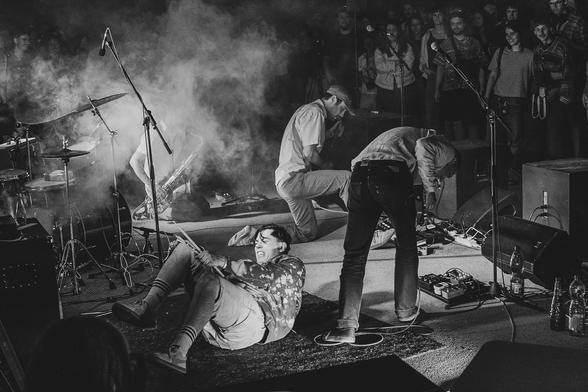 drummer laying on the ground, braking the drumstick. other members quite distressed as well