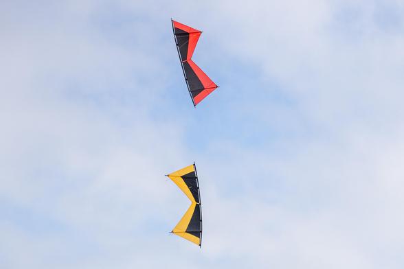 A red and gold quad line kite in formation