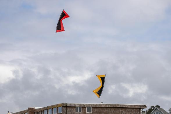 A red and gold quad line kite in formation