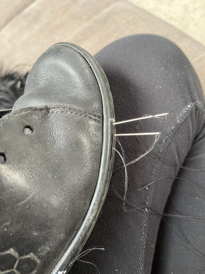 The successful process of sewing the shoe back up using two needles and threads to make a strong repair