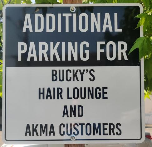 A sign reading "Additional parking for Bucky's Hair Lounge and AKMA Customers."

The sign refers to three businesses: Bucky's (auto repair), Hair Lounge (hair place), and AKMA (Academy for Kempo Martial Arts). Without punctuation, it looks like one listing.