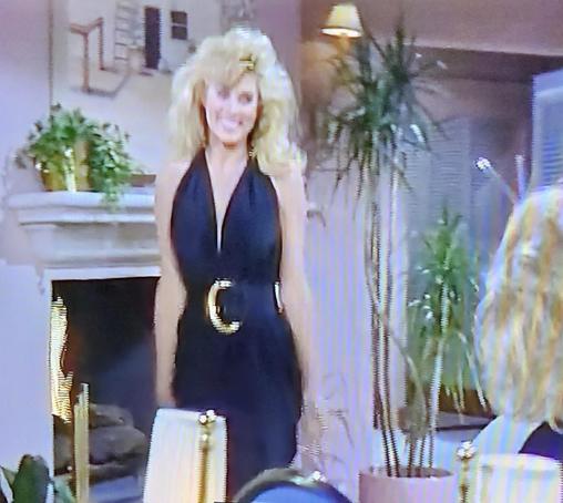 Big 1980s hair gal wearing a halter dress with massive belt & belt buckle.