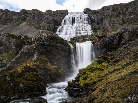 Cascading wide waterfall in a rocky landscape