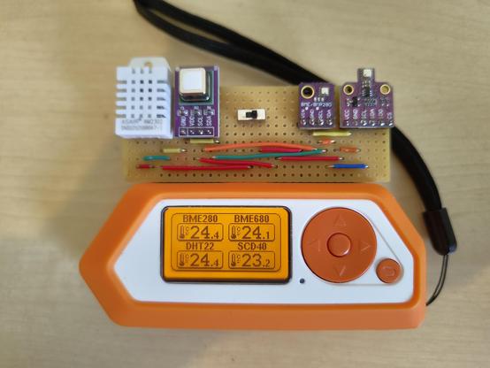 Flipper Zero with DIY Modul with four sensors attached. 
Sensors from left to right: DHT22, SCD-40, BME280, BME680.
The Flipper screen shows four temperature readings from four different sensors. Upper left corner BME280 with 24.4, upper right corner BME680 with 24.1, lower left corner DHT22 with 24.4 and lower right SCD-40 with 23.2.
