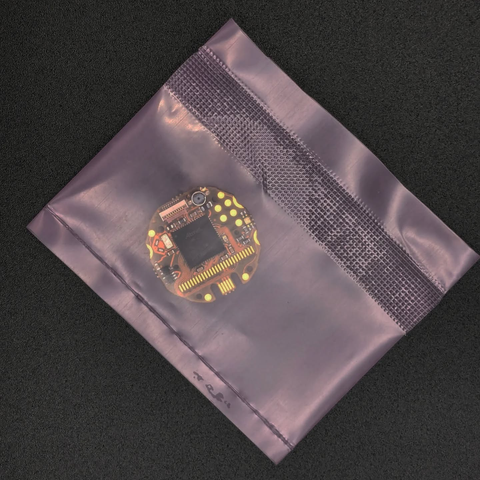 The Sensor Watch Pro—a drop-in replacement PCB—for the Casio F-91W inside of a plastic bag on a black bakground.