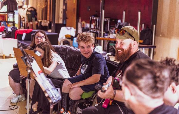 A group of people sitting on a couch, joyfully playing various musical instruments together