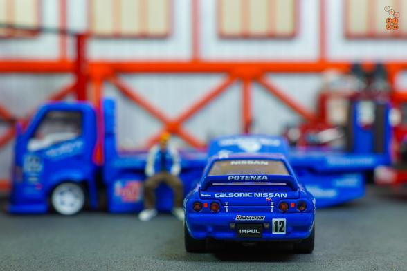 A rear side of Nissan Skyline GT-R R32, JTC 1990 on Calsonic livery in 1:64 scale with 1:64 figure on AREA 164