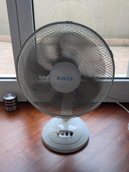 Foto di un ventilatore acceso scattata con la modalità esposizione lunga del cellulare. La griglia di protezione delle pale è tutta confusa e deformata a causa degli algoritmi utilizzati per simulare la modalità di esposizione richiesta.