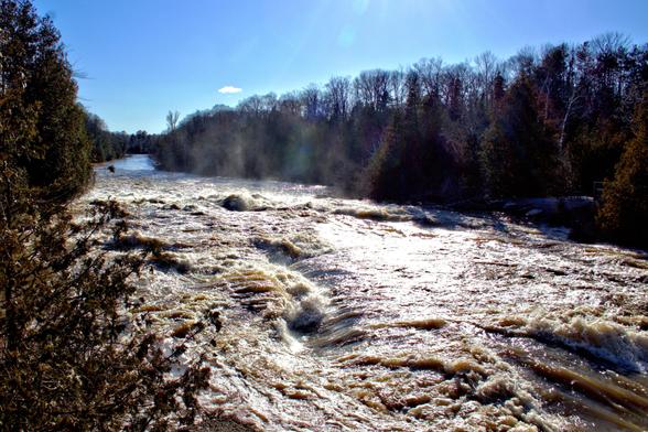 Sauble River below the falls, early spring flood. Mist rising over river.