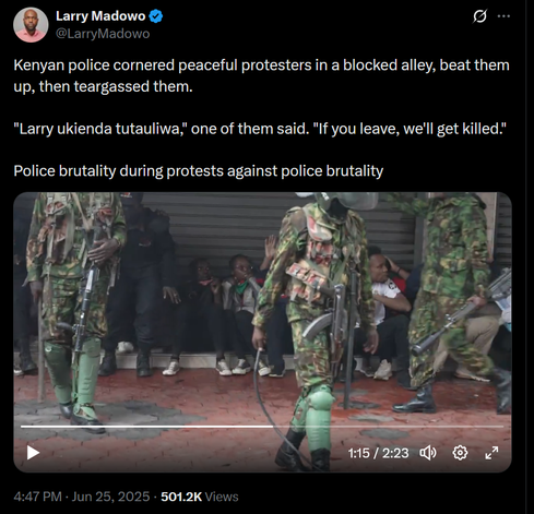 The image is a screenshot of a tweet from Larry Madowo, a verified account. The tweet describes an incident where Kenyan police cornered peaceful protesters in a blocked alley, beat them up, and then teargassed them. The tweet includes a quote from one of the protesters, "Larry ukienda tutauliwa," which translates to "If you leave, we'll get killed." The tweet's title reads, "Police brutality during protests against police brutality."

Below the text, there is a video thumbnail showing a scene with Kenyan police officers in camouflage uniforms and protective gear, including helmets and knee pads, standing in front of a group of seated individuals. The officers are armed with rifles, and the individuals appear to be in a defensive posture. The video has a timestamp of 1:15 out of 2:23, and it has garnered 501.2K views. The timestamp on the tweet indicates it was posted at 4:47 PM on June 25, 2025.